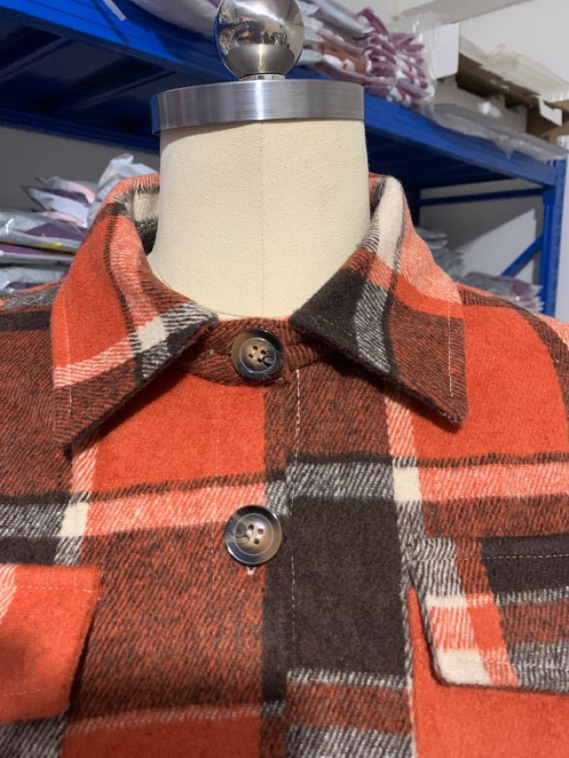 Détail col et boutons du manteau long écossais orange en tissu tartan à carreaux marron et blanc