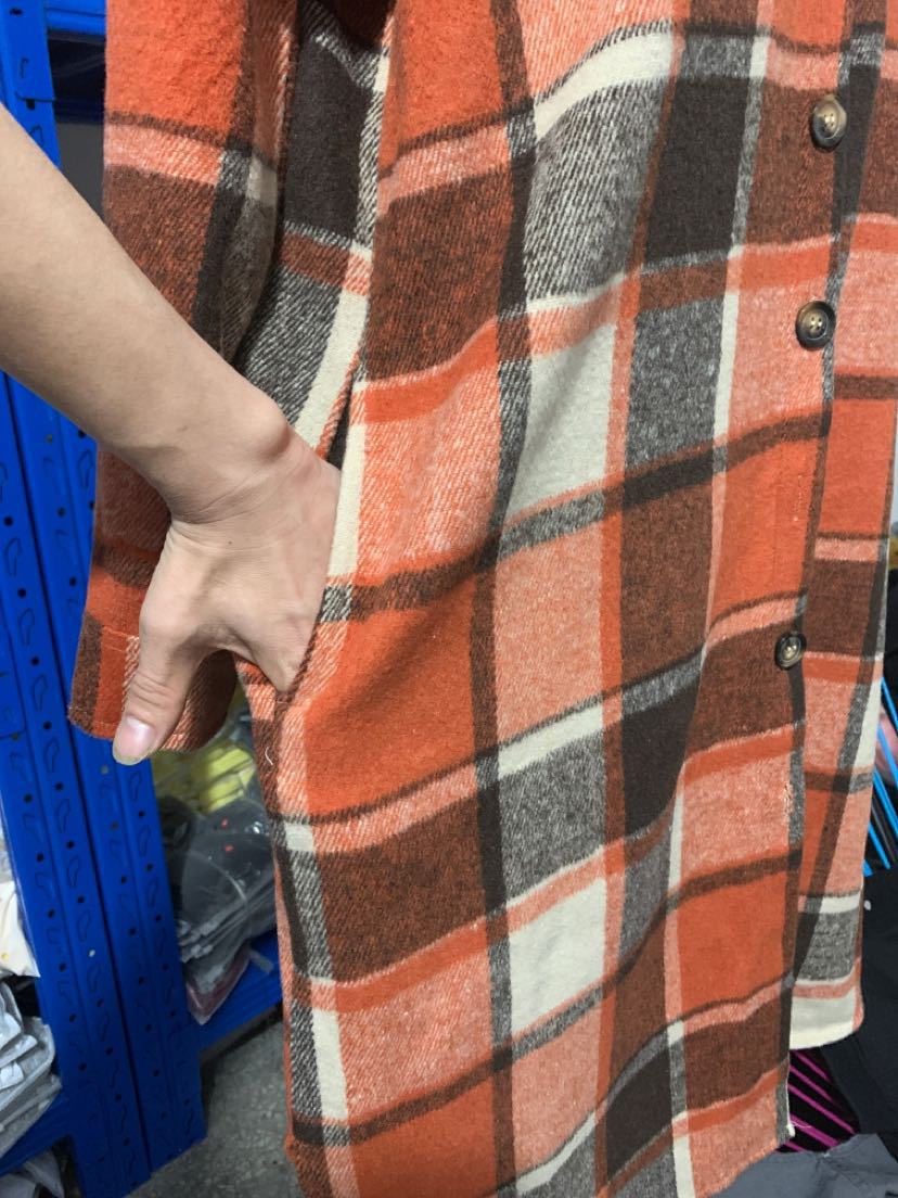 Détail poche latérale du manteau long écossais orange en tissu tartan à carreaux marron, orange et blanc