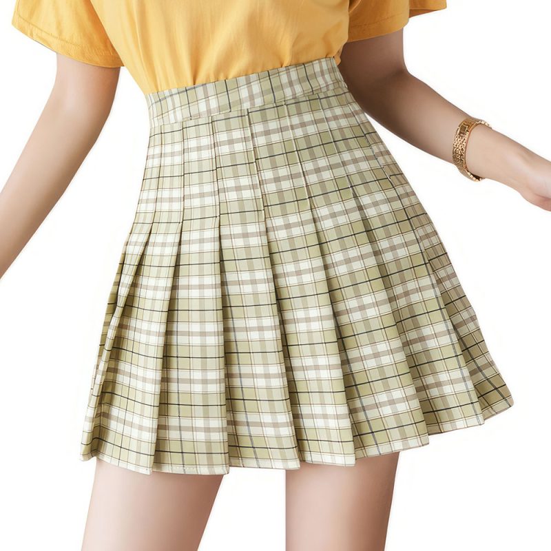 Jupe écossaise vert clair plissée en tissu tartan à carreaux portée avec un haut jaune