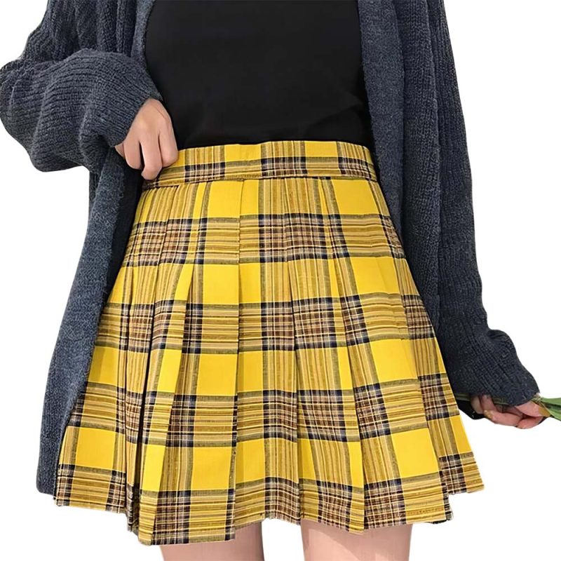 Jupe tartan jaune plissée en tissu écossais portée avec un haut noir et un cardigan gris