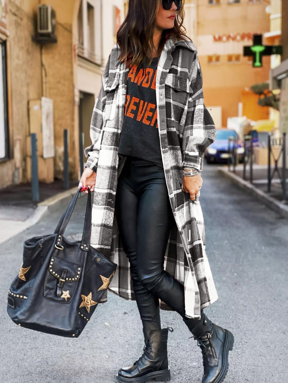 Femme portant un manteau écossais noir et blanc à carreaux, coupe longue avec poches latérales, style casual chic urbain