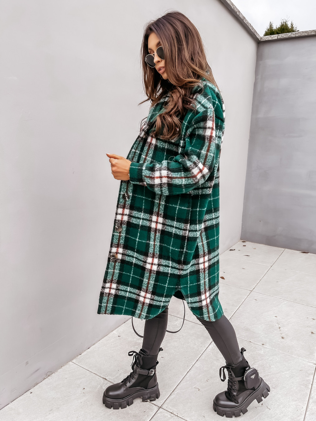 Manteau long en tartan vert à carreaux blancs et noirs porté de profil, style urbain avec bottines noires à semelle épaisse