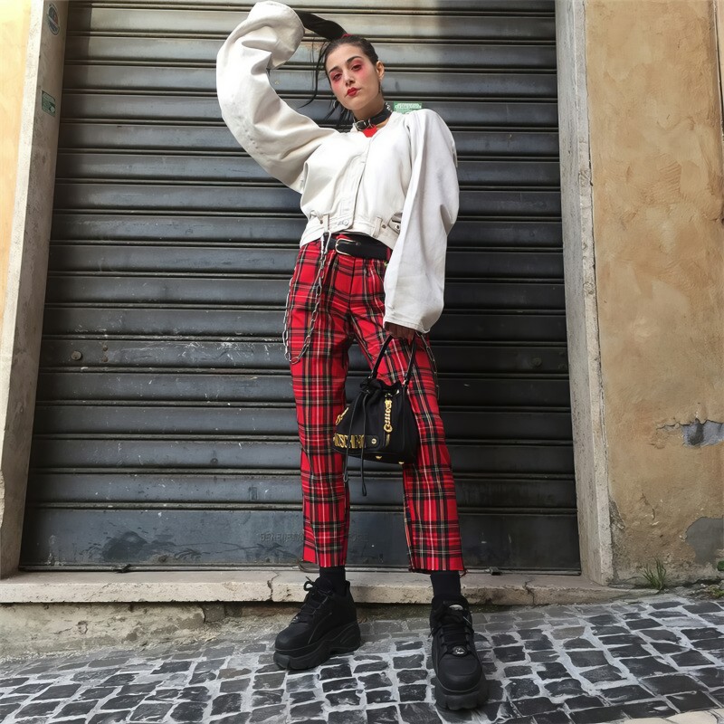Pantalon femme en tissu carreaux tartan rouge avec coupe droite et taille haute porté avec sweat blanc et chaussures noires