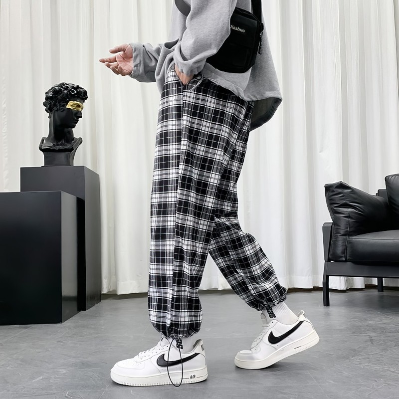 Pantalon écossais à carreaux noir et blanc avec bas resserré porté en intérieur moderne