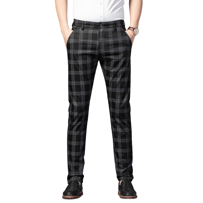 Pantalon écossais long gris foncé à carreaux blancs porté avec une chemise blanche, coupe droite et poches latérales