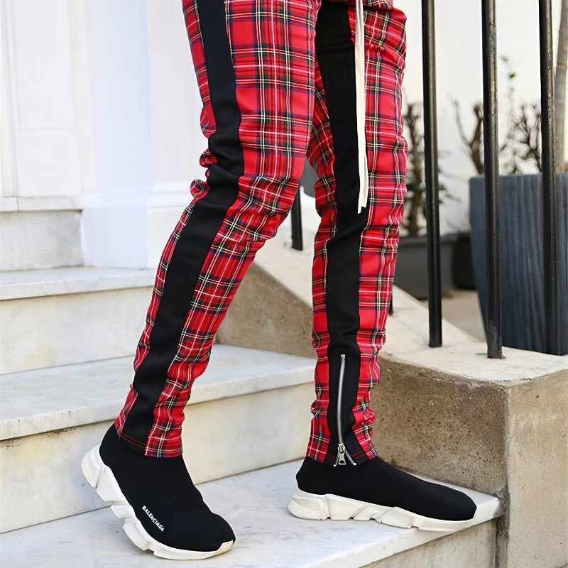 Pantalon écossais slim homme rouge à motif tartan avec bande noire latérale, vue en pied sur escaliers