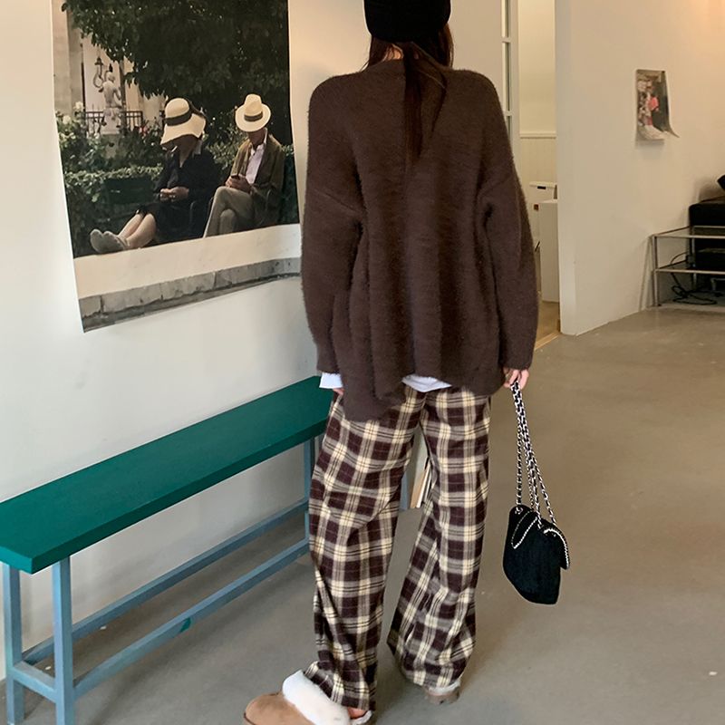 Pantalon large à carreaux écossais femme en tissu doux avec motif tartan marron et beige, porté de dos dans un intérieur moderne
