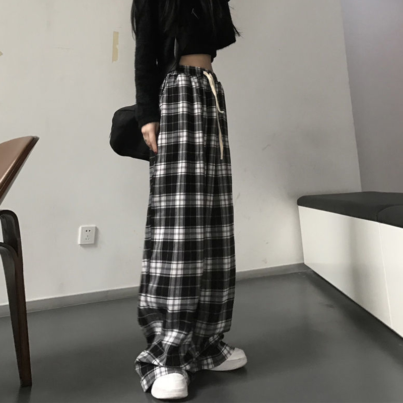 Pantalon large femme à carreaux écossais noir et blanc avec cordon de serrage visible, porté de profil
