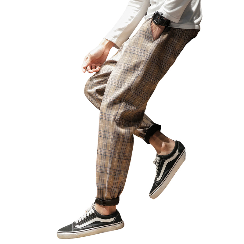 Pantalon tartan beige homme coupe décontractée avec poignets élastiques aux chevilles porté avec baskets noires et blanches