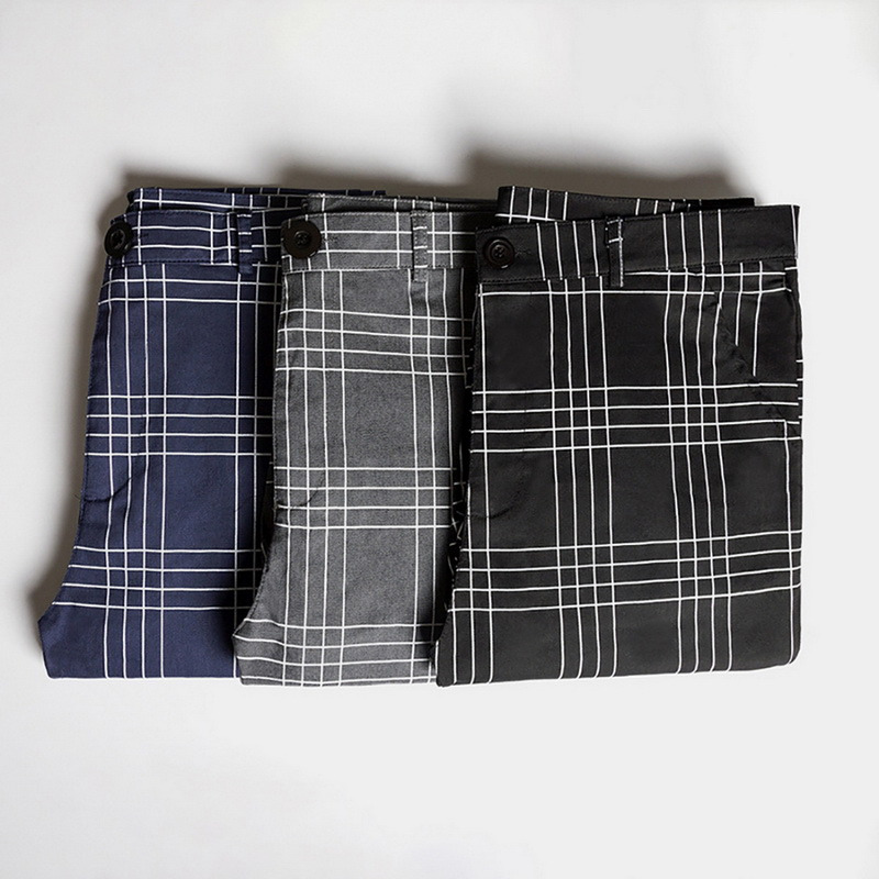 Trois pantalons tartan à carreaux homme slim pliés en bleu marine, gris et noir avec motif écossais classique