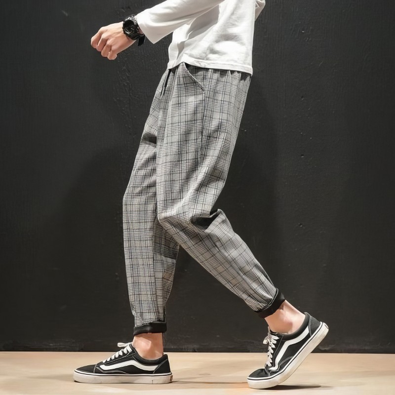 Pantalon tartan gris homme coupe décontractée avec bas resserré porté de profil