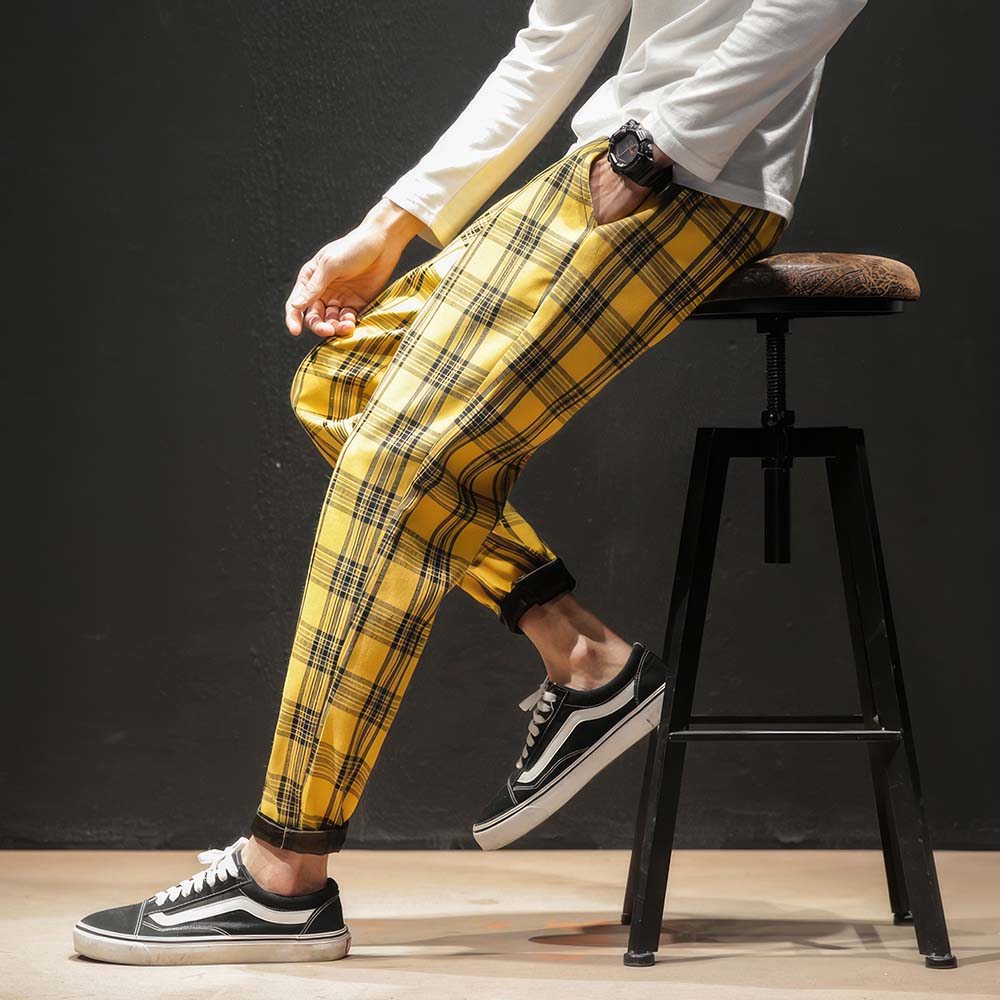 Pantalon tartan jaune à carreaux homme porté assis, vue latérale sur la jambe droite avec motif écossais classique