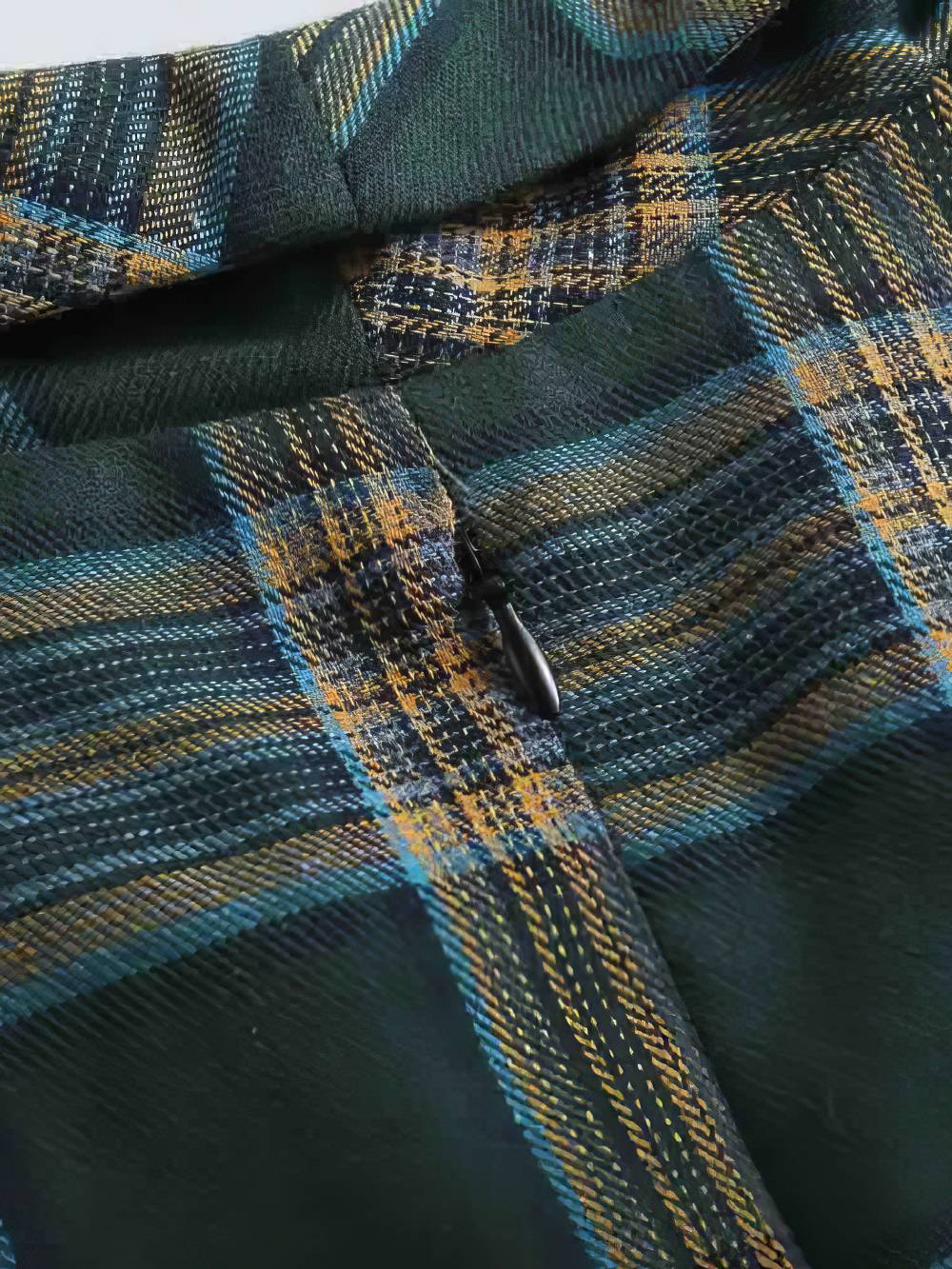 Détail de la fermeture éclair sur la robe écossaise vintage à carreaux vert et beige en tissu tartan