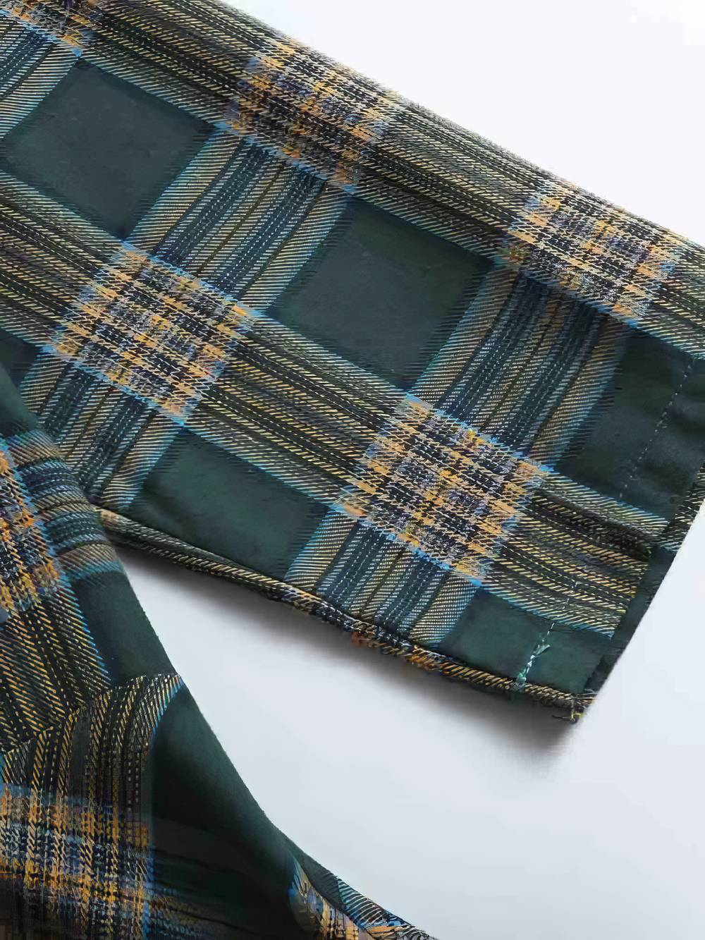 Détail de la manche d'une robe écossaise vintage à carreaux vert et beige avec motif tartan traditionnel