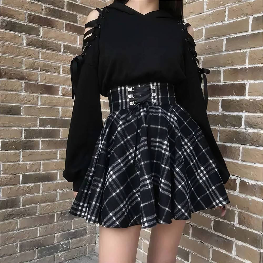 Jupe écossaise ceinture à lacets noir et blanc en tissu à motif tartan, vue de face portée avec taille haute et jupe plissée