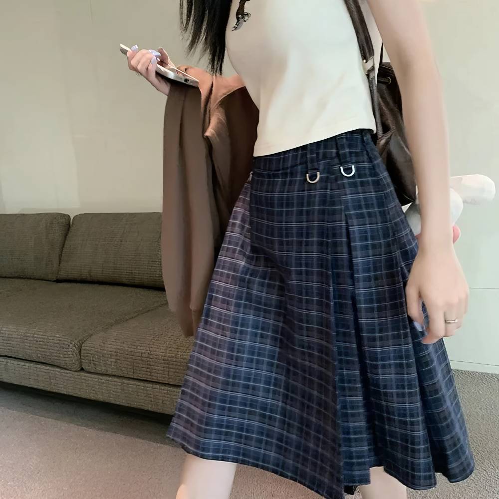 Jupe écossaise longue tartan bleu et noir vue de face portée avec détails de plis et anneaux métalliques sur la taille