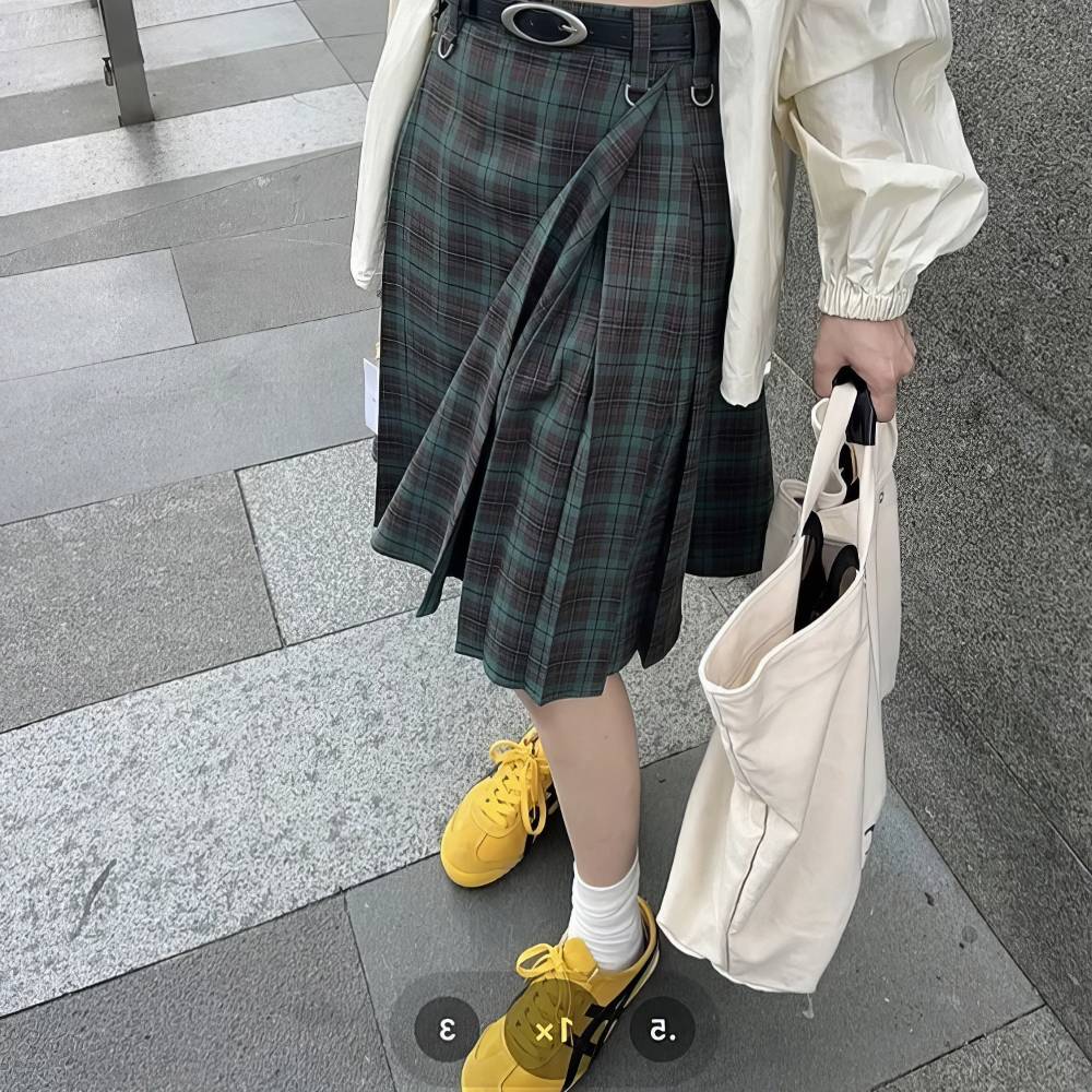 Jupe écossaise longue en tartan vert et noir portée, vue en pied avec détail du motif tartan et ceinture à œillets métalliques