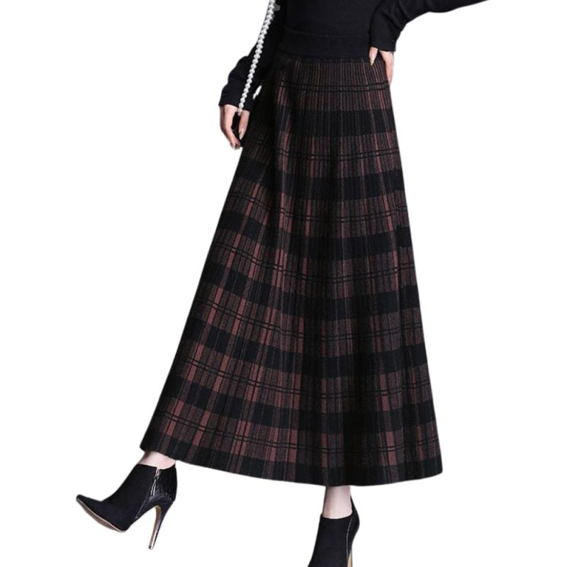 Jupe longue écossaise à carreaux sombres en tissu tartan plissé portée avec bottines à talons