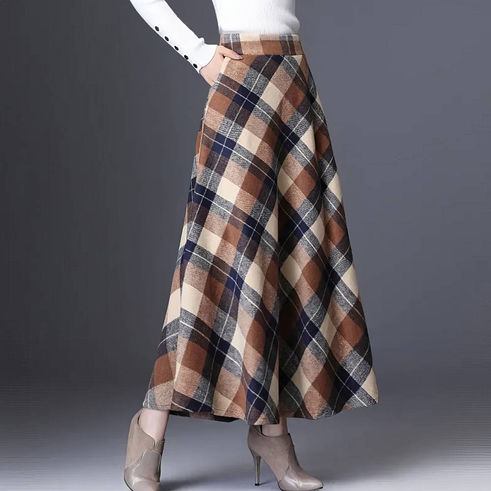 Jupe longue évasée en tissu écossais marron et noir avec motif tartan, vue de profil montrant la coupe fluide et la longueur jusqu'aux chevilles
