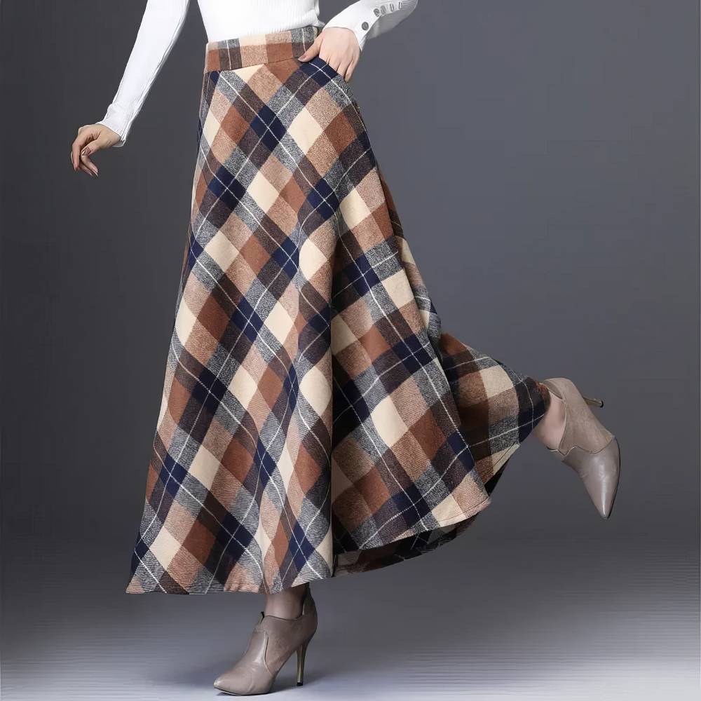 Jupe longue évasée écossaise marron et noir en tissu à carreaux tartan portée de profil sur fond gris