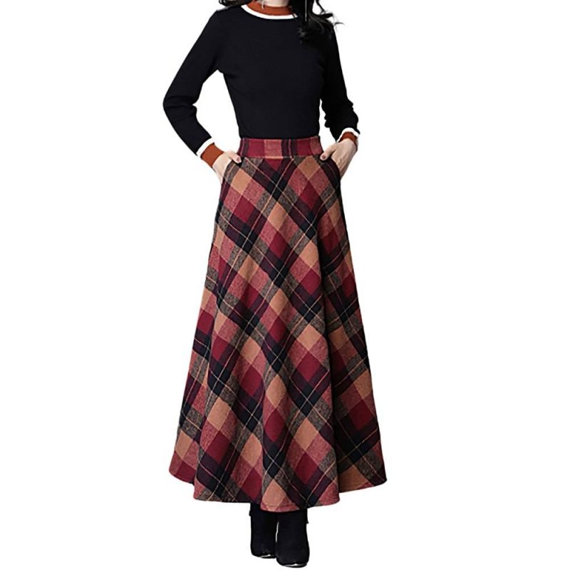 Jupe longue évasée écossaise en tissu tartan rouge et beige portée avec un pull noir