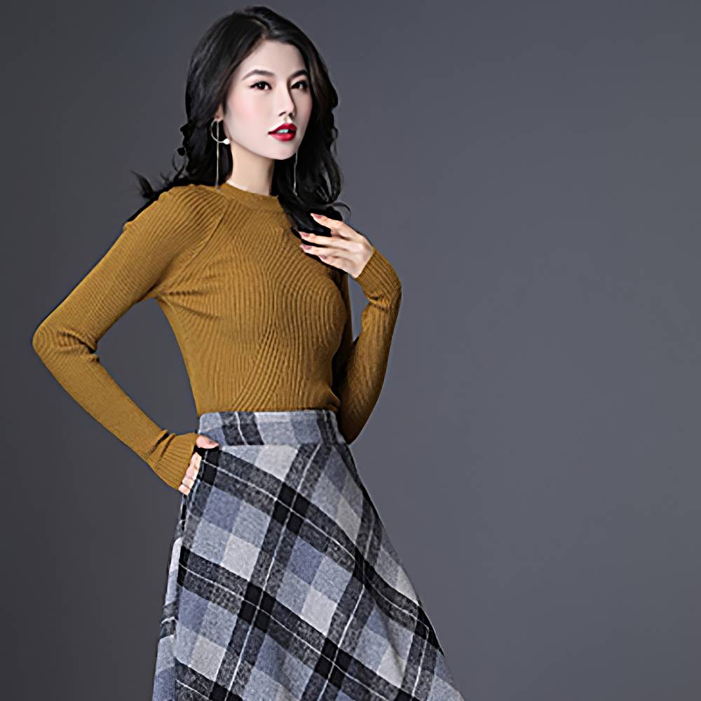 Jupe longue évasée écossaise gris et noir avec motif tartan portée de profil par une femme en pull moutarde