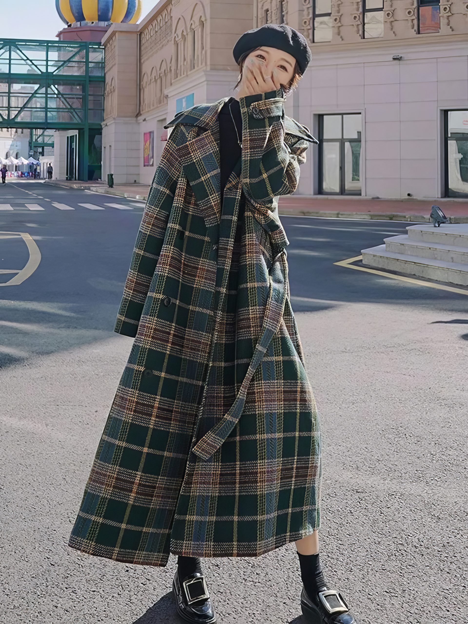 Manteau long écossais à carreaux vert et beige avec ceinture, porté en extérieur, style urbain et chic