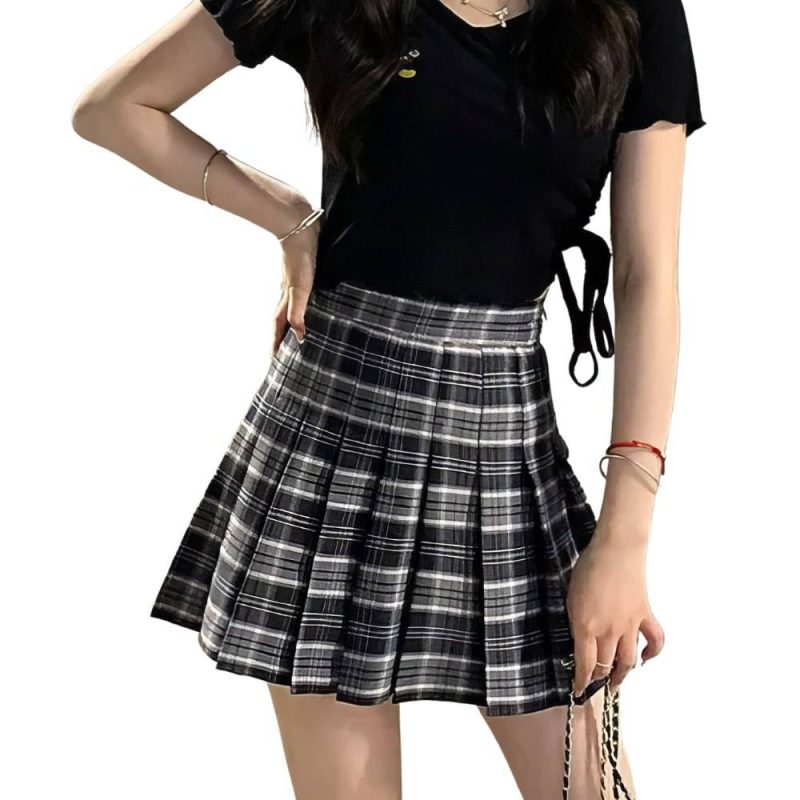 Mini jupe plissée en tissu tartan noir et blanc portée par une femme, style kilt écossais moderne