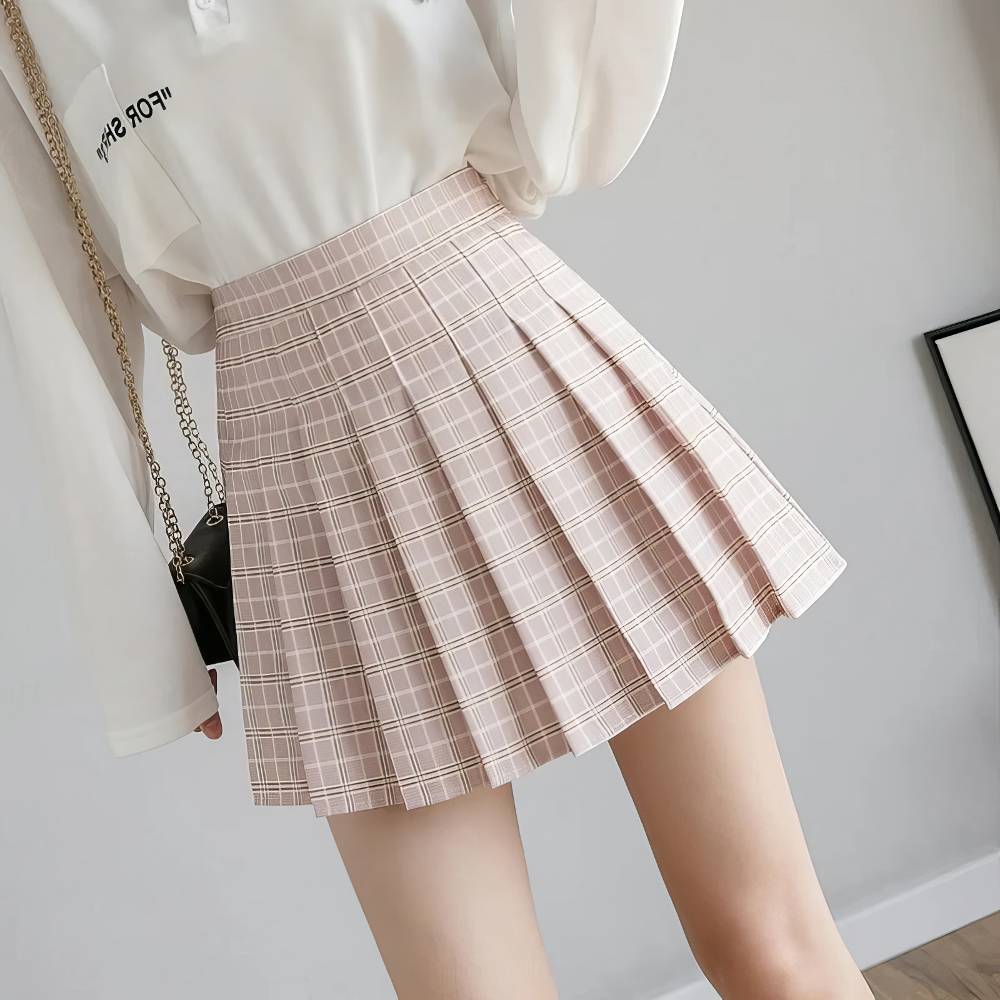 Mini jupe plissée à motif tartan rose et blanc portée de face, style casual chic
