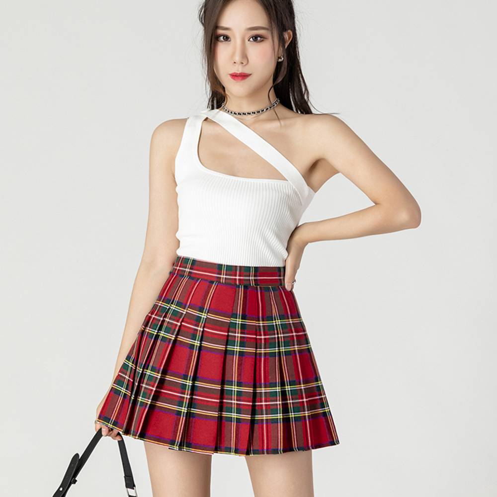 Mini jupe plissée tartan rouge et vert portée par une femme, motif écossais classique avec plis réguliers