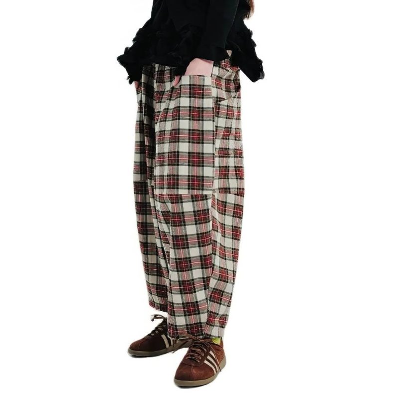 Pantalon bouffant écossais à carreaux rouge et beige en tissu tartan avec poches latérales porté de profil