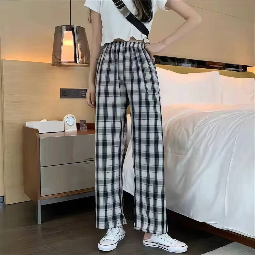 Pantalon écossais femme urbain noir et blanc à taille élastique, motif tartan, style décontracté, porté avec baskets blanches
