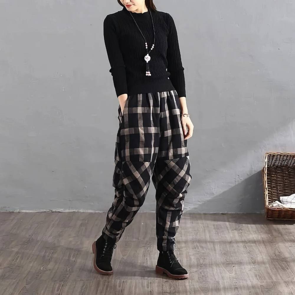 Pantalon harem femme noir et beige motif écossais tartan, coupe ample et taille élastique, porté avec pull noir et bottines noires