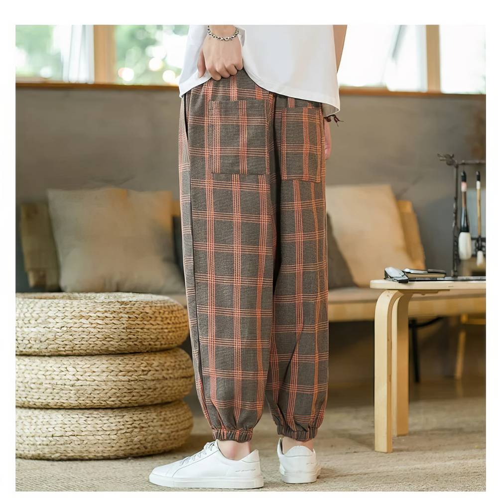 Pantalon écossais homme large marron et orange avec motif tartan, vue arrière du bas du pantalon resserré aux chevilles