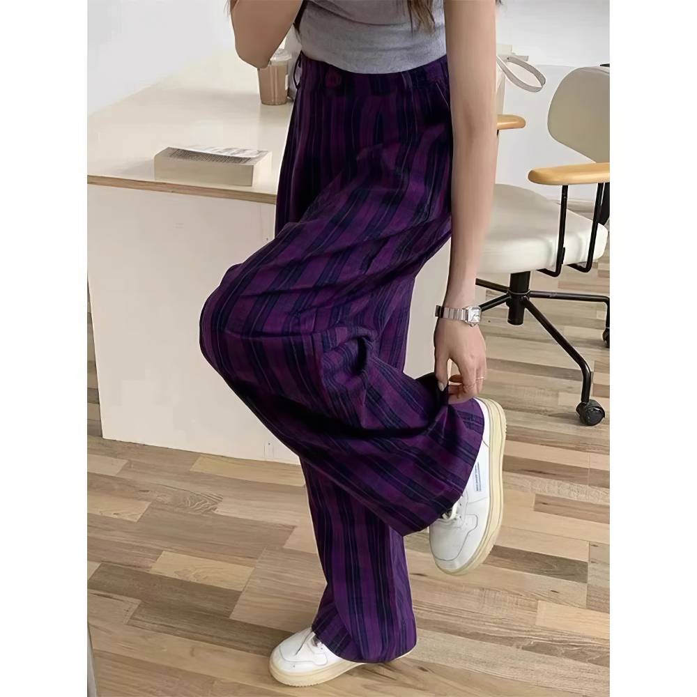Pantalon écossais femme violet et noir en tissu tartan, coupe ample et fluide, porté avec des baskets blanches
