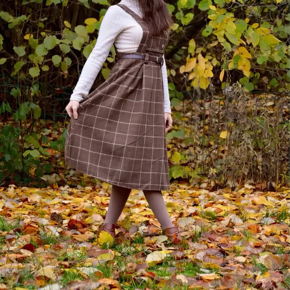 Robe écossaise chasuble marron à motif tartan avec ceinture, vue de côté sur fond d'automne
