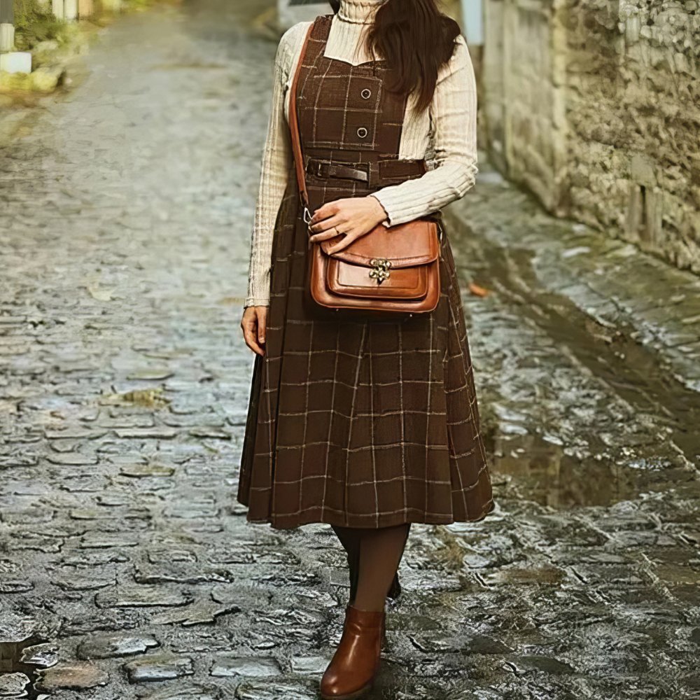 Robe écossaise chasuble marron à motif tartan avec ceinture, vue de face en pied sur chemin pavé
