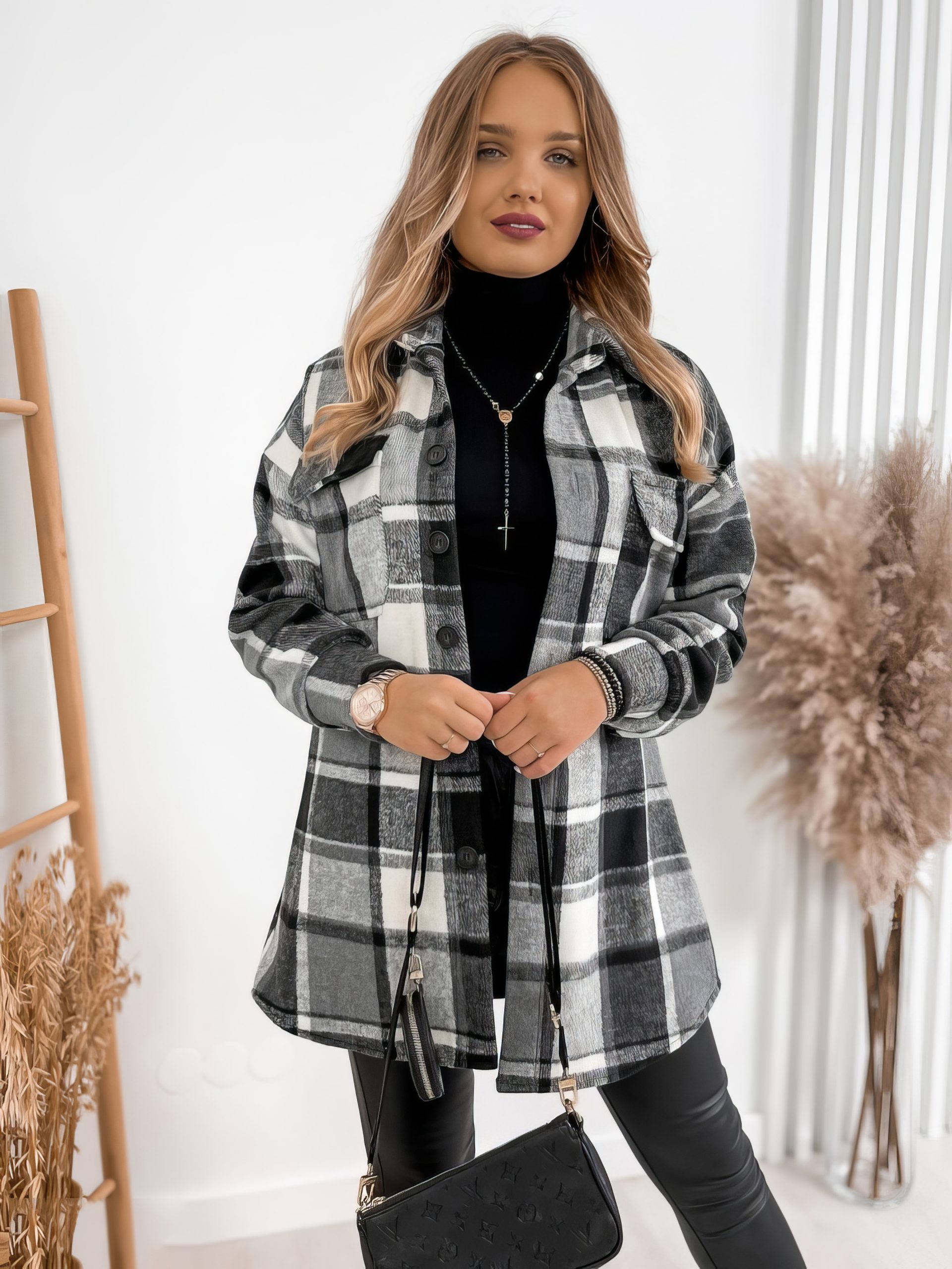 Veste écossaise longue à carreaux noir et blanc en tissu épais portée par une femme, style casual chic avec col chemise et boutons sur le devant