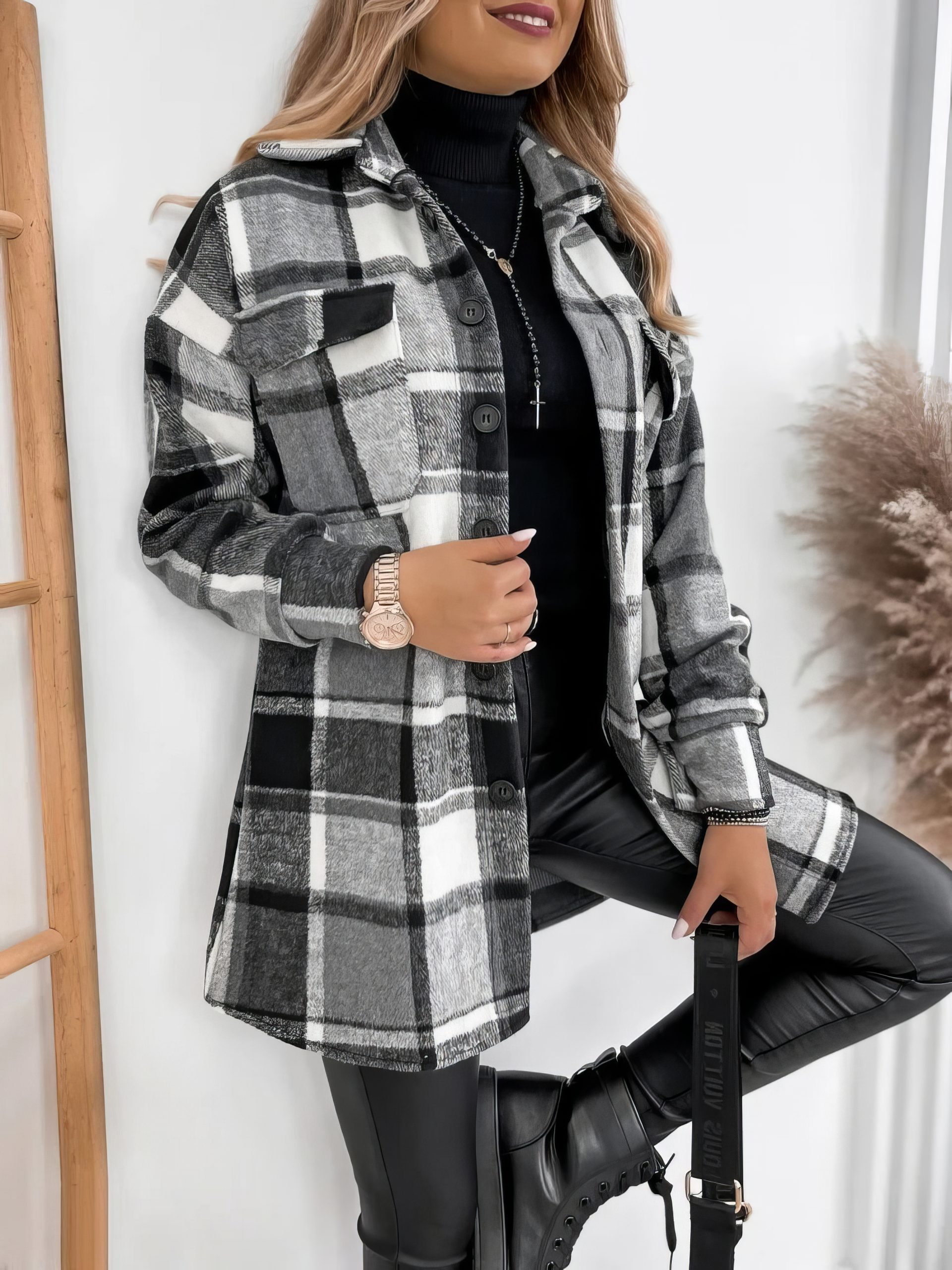Veste écossaise longue à carreaux noir et blanc en tissu épais avec poches plaquées, portée sur un pull noir